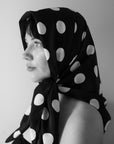 Woman wearing large square silk scarf by nessi tied around head, black with white polka dots, Australian independent fashion label.