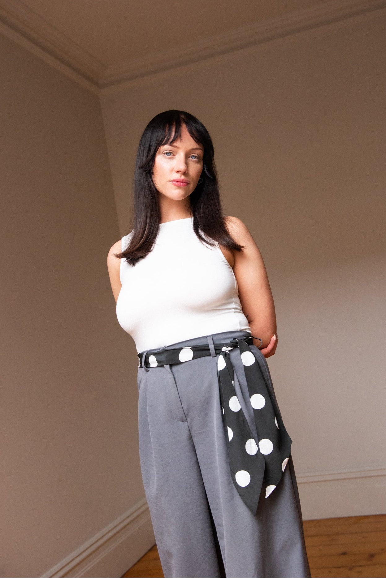 Handmade silk skinny scarf styled as a belt on a woman, black with white polka dots, by nessi, an Australian independent fashion label