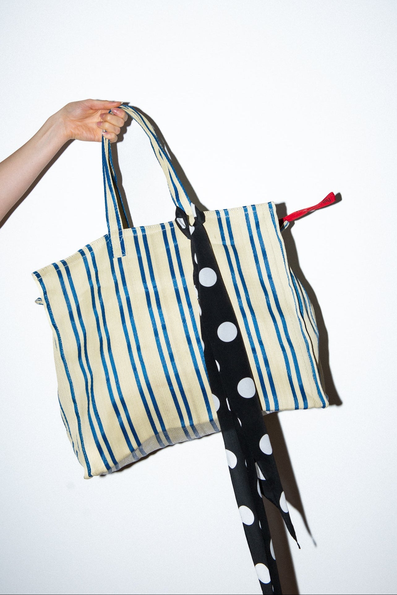 Handmade silk skinny scarf tied on a bag, black with white polka dots, by nessi, an Australian independent fashion label.